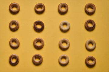 Top view of Sushki pattern on yellow surface. dish of Russian and Ukrainian cuisine, solid ring-shaped product made of dough, type of mutton products. One of the most common tea snacks among Slavs