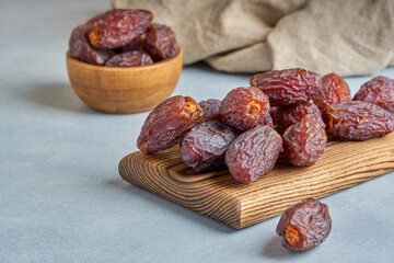 Medjool dates on wooden board. Closeup, copy space