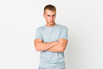 Young caucasian handsome man frowning face in displeasure, keeps arms folded.