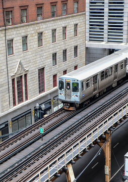 High angle view of vintage commuter train and tracks in among the city skyscrapers