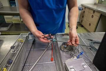 in sterilization department of a hospital, surgical instruments are sorted into trays after cleaning