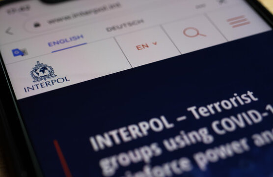 Viersen, Germany - December 29. 2020: Close up of mobile phone with website of interpol with warning about covid-19 terrorists