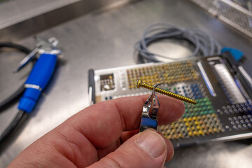 many different types of titanium surgical screws are sorted into a tray according to size and type