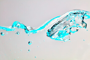 Nahaufnahme einer blauen Welle und Luftblasen vor hellem Hintergrund.