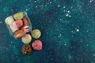 A glass jar full of small colorful doughnuts