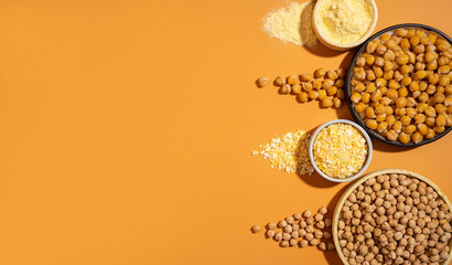 Raw and cooked chickpeas, chickpea flour and flakes ceramic plate bowl isolated on beige orange...