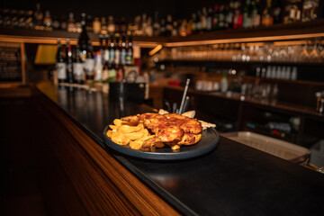 Amazing portrait of a delicious dish of chicken and potatoes placed on a bar counter