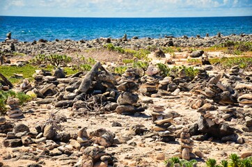 cairn at the sea of caribbean, island of bonaire, antilles abc island netherlands, stone by the sea, rocks on the beach, art on the beach