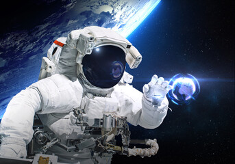 Astronaut on the orbit trying to catch digital earth ball globe. Elements of this image furnished by NASA - obrazy, fototapety, plakaty