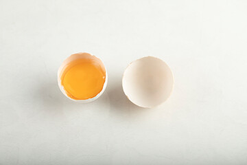 Broken organic egg on white background
