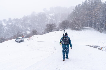 A young photographer walking in the aizkorri mountain of gipuzkoa. Snowy landscape by winter snows. Basque Country, Spain