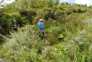 Obraz premium Boy in a hat and big clothes on the background of summer nature