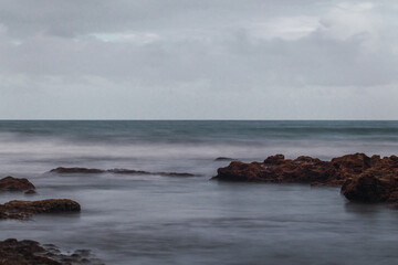 shore of a yellow sand beach with a cloudy day