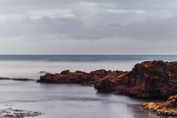 shore of a yellow sand beach with a cloudy day