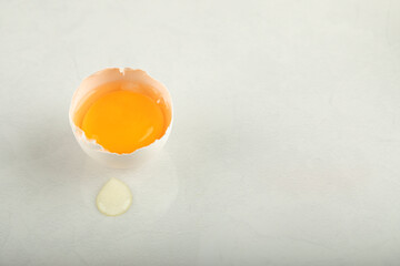 Raw broken egg on white background