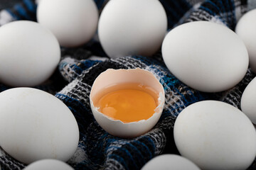 Egg yolk and white eggs on striped cloth