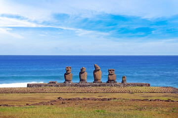 Moai statues at the Ahu Tahai Ceremonial complex on Easter Island, against a blue sky covered by white clouds.