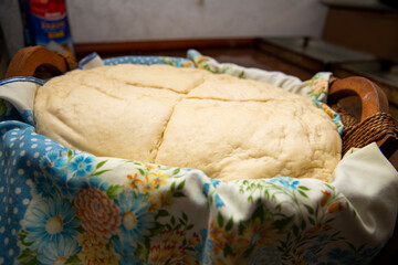 Leavened dough inside a wooden basket covered with a warm blanket, and then cut into parts ready to be worked, to make desserts and pizza. after hours of rising.