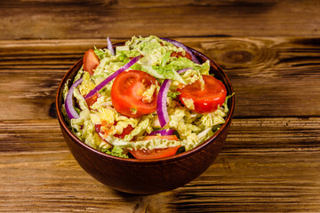 Vegan salad with savoy cabbage, tomatoes and onion in a ceramic bowl