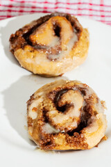 Hand made tasty cinnamon roll on a white plate. Pastry product.