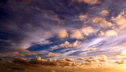 View from the coast of the Easter Island, of colorful sunset sky covered by white clouds, over the Pacific Ocean.