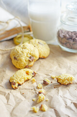 Chocolate chip cookies served with milk on rustic background