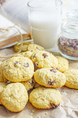 Chocolate chip cookies served with milk on rustic background