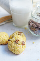 Chocolate chip cookies served with milk on rustic background
