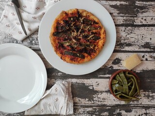 Homemade pizza with flatbeans on an old wood table