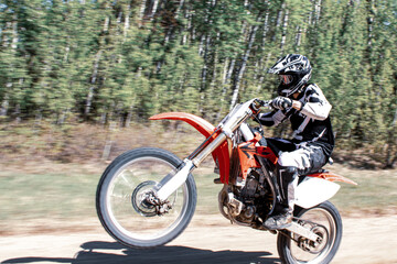 Fototapeta na wymiar Wheelie dirt bike rider one wheel high speed motorbike