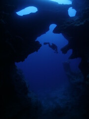 Fototapeta na wymiar Scuba divers underwater exploring caves blue ocean scenery
