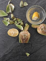 Artichokes and lemon slices on a dark background
