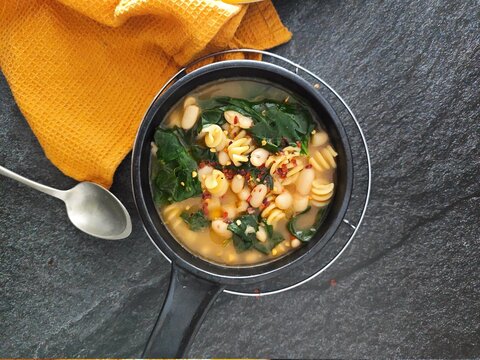 Tastefull  Green Leaves Soup In A Dark Silver Background And Yellow Table Setting