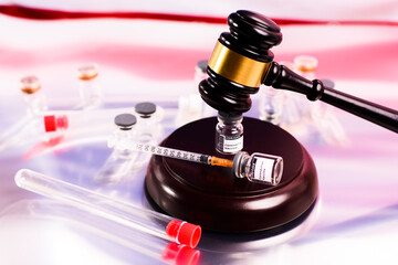 Adverse effects of the vaccine are claimed in court seeking compensation, gavel on vial of vaccines.
