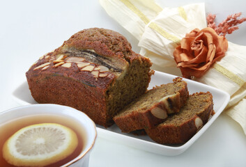 Sliced banana bread with walnuts on white background