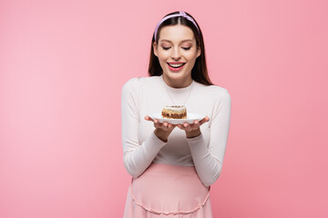  young pretty pregnant woman with cake isolated on pink