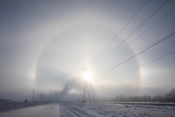 Sun halo winter powerlines in Alberta.