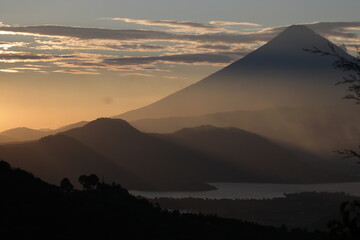 sunset in the mountains with volcano over a lake in Guatemala