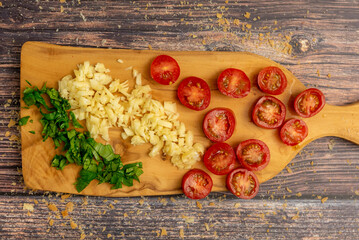 Fresh Sliced basil, garlic, and cherry tomato on a cutting board