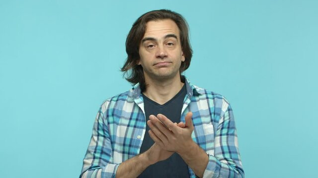 Slow motion of skeptical middle aged guy smirk with bored face, clap hands slowly, applause sarcastic and standing over blue background