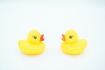Two yellow ducklings facing each other against a white background