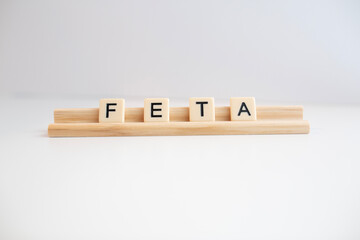 the word feta cheese written in scrabble titles against a white background
