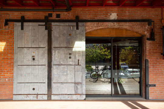 Old Red Brick Building With Large Metal Warehouse Doors On Sliding Track Exposed Glass Office Doors To Old Train Station