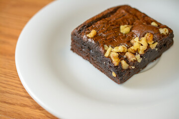 Fototapeta na wymiar Rich chocolate brownie topped with chopped walnuts