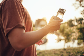 handsome man hold water bottle on a sunny day after running. Sport, fitness workout concept.