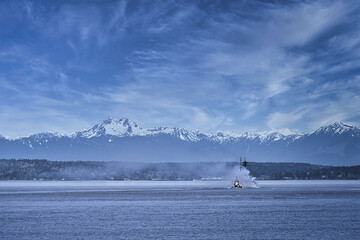 2020-12-29 A LARGE SHIP IN PUGET SOUND WITH THE CASCADE MOUNTAINS IN THE BACKGROUND WITH LIGHT BLUE...