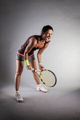 Professional female tennis player. Angry girl screaming with racket in hands