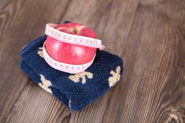 Fototapeta premium A red apple wrapped by a tape on the towel