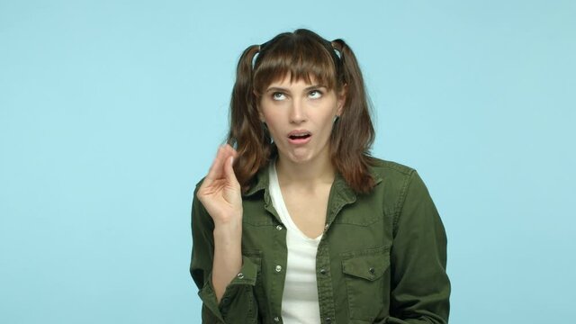 Slow motion of annoyed funny girl mocking someone talkative, showing blah blah gesture and roll eyes irritated, standing over blue background