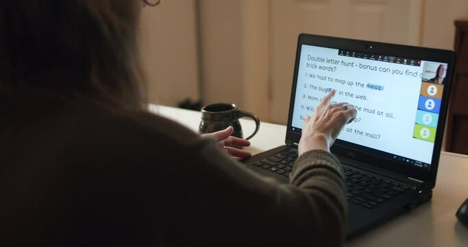 Young woman teaching remote class language and spelling from home on a laptop.